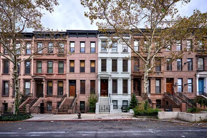 Row of historic brownstone townhouses with stoops and trees