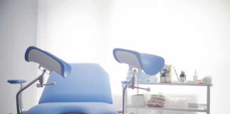 Gynecological exam chair with blue padding in a clinic room