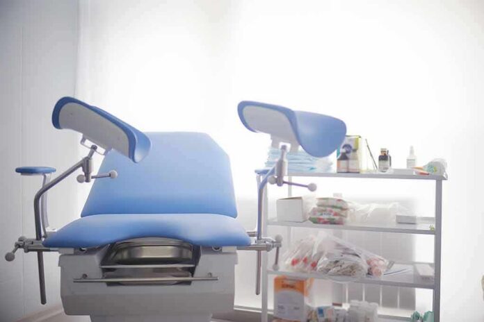 Gynecological exam chair with blue padding in a clinic room