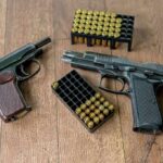 Texas Judge Deals Major Blow To NFA Two handguns and boxes of ammunition on a wooden floor
