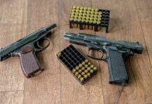 Texas Judge Deals Major Blow To NFA Two handguns and boxes of ammunition on a wooden floor