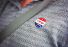 How One Fake Citizen Beat The System I voted sticker on a gray shirt under a seat belt