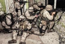Trump’s Drug War Gains A Powerful Ally soldiers in camouflage gear take positions inside a damaged building