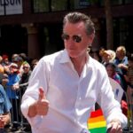 Transparency Fight Exposes Newsom’s Mystery Gaps Man in white shirt giving thumbs up at a pride parade