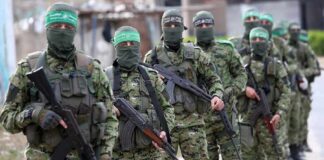 Armed men in camouflage uniforms standing in a line