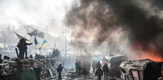 A chaotic protest scene with smoke, fire, and people holding flags