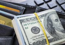 Governor’s Gamble: Data Cash, No Income Tax Roll of US hundred-dollar bills on wallet