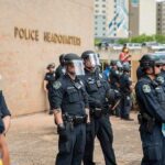 Child Predator Hunt Snaps Shut In Fairfax Police officers in riot gear stand in formation outside a headquarters building