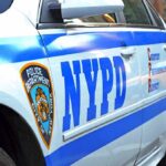 NYPD police car side with blue stripes and emblem
