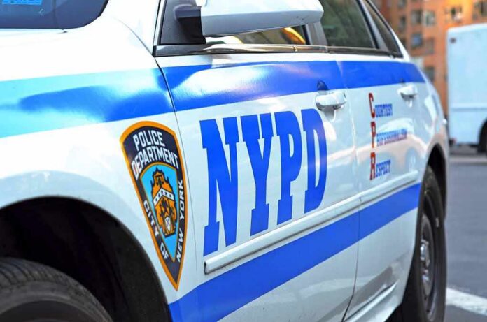 shutterstock_1910596186 NYPD police car side with blue stripes and emblem