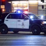 Police SUV blocks an intersection at night with lights flashing