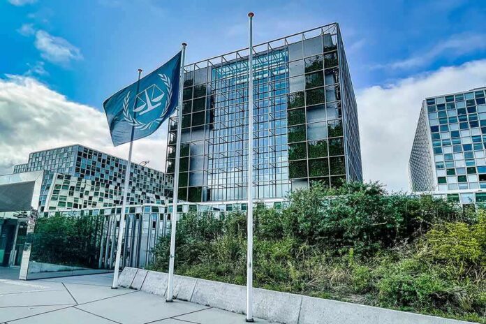 shutterstock_2292903153 Modern glass office building with blue flag and greenery