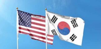 United States and South Korea flags waving against a clear blue sky