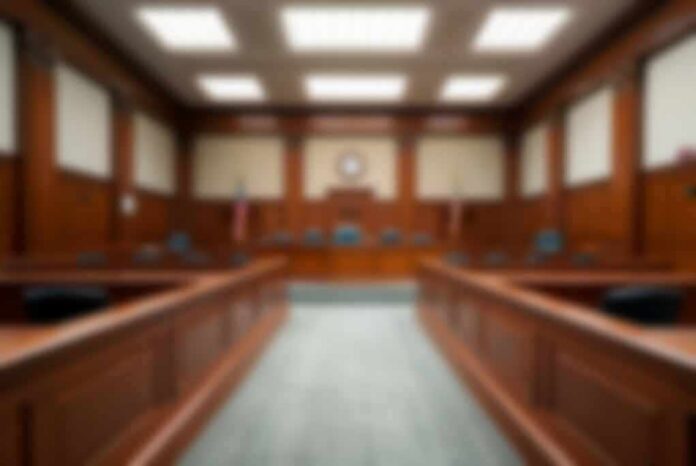 shutterstock_2324977165 Empty courtroom with wooden benches and judge's bench