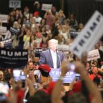 Trump Tests His Grip in South Carolina man at podium addressing a large crowd at a rally