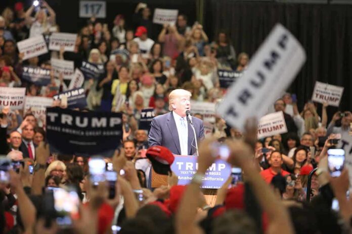 shutterstock_426567685 man at podium addressing a large crowd at a rally