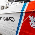 US Coast Guard ship hull with emblem and red stripe
