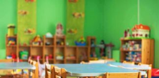Preschool classroom with small tables and wooden chairs