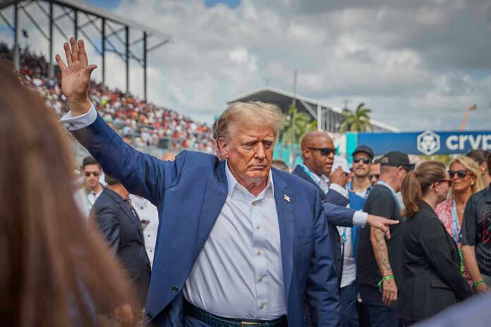 2458373881 Person in blue suit waving at outdoor event.
