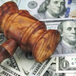 Taxpayer Cash Covers ICE Detentions? Wooden judge's gavel on scattered US dollar bills