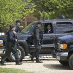 Alex Blumberg in SUV as armed security officers walk by