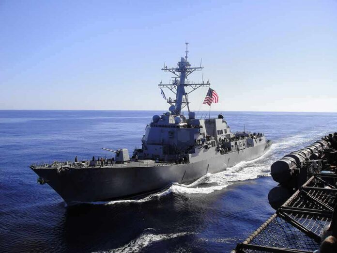 naval destroyer sailing at sea with flag flying