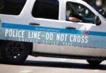 Trump Warns Chicago Could “Die” Without Help Police barricade with patrol SUV in background