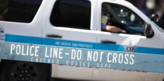 Trump Warns Chicago Could “Die” Without Help Police barricade with patrol SUV in background