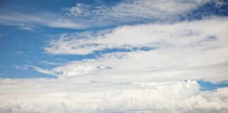 White passenger boat cruising on open sea under cloudy sky