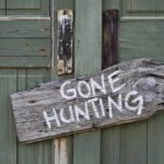 Weathered wooden sign on green door