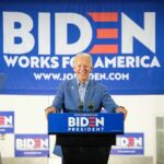 Cuomo Explodes: Did Biden Sabotage Dems? smiling man at podium during campaign event