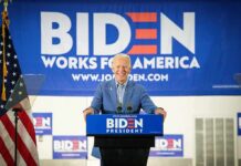 smiling man at podium during campaign event