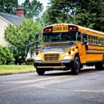 Yellow school bus driving on a suburban street