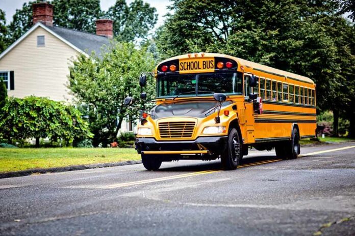 Yellow school bus driving on a suburban street
