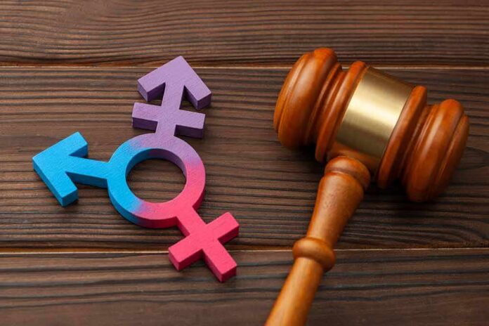 shutterstock_1620731128 Wooden gavel beside multicolored transgender symbol