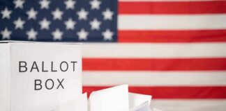 Mail-Vote Exemption Masks Risky Power Play Ballot box with papers in front of an American flag