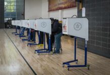 Big Donors Muscle Election Rules Voters at polling booths in a gymnasium