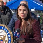 Why AOC Refused The Fox Invitation Woman speaking at outdoor press event with microphones and seal