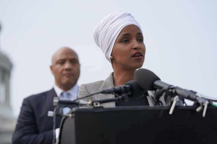 shutterstock_2012384414 Woman in white headwrap speaking at microphones outdoors
