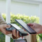 Customer paying with smartphone at contactless card reader