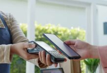 Banks Panic Over Trump Fee Blitz Customer paying with smartphone at contactless card reader