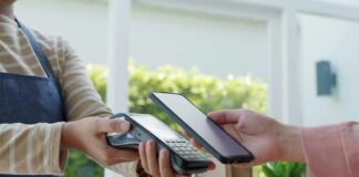 Banks Panic Over Trump Fee Blitz Customer paying with smartphone at contactless card reader