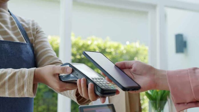 Customer paying with smartphone at contactless card reader
