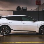 Amazon’s Robotaxi Gets a Wild Pass white electric crossover parked on rooftop in side profile