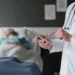 New York Approves Death Drugs Doctor using tablet beside hospital patient