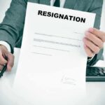 Person in suit holding a resignation letter