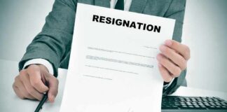 Person in suit holding a resignation letter