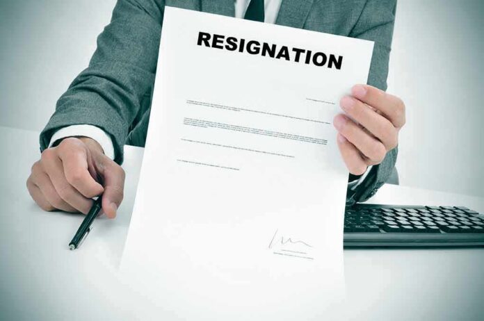 Person in suit holding a resignation letter