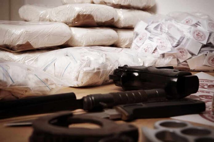 Piles of bagged powder with a handgun on a table