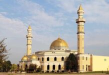 Noise War Explodes In Michigan Mosque with golden dome and two tall minarets under a partly cloudy sky